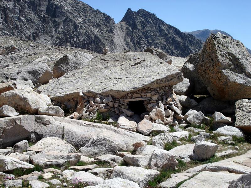 Refugio-vivac en el Ibón Medio de Coronas (2760 m), justo detrás, al fondo, se aprecia con claridad la brecha inferior de Llosars (2833 m)